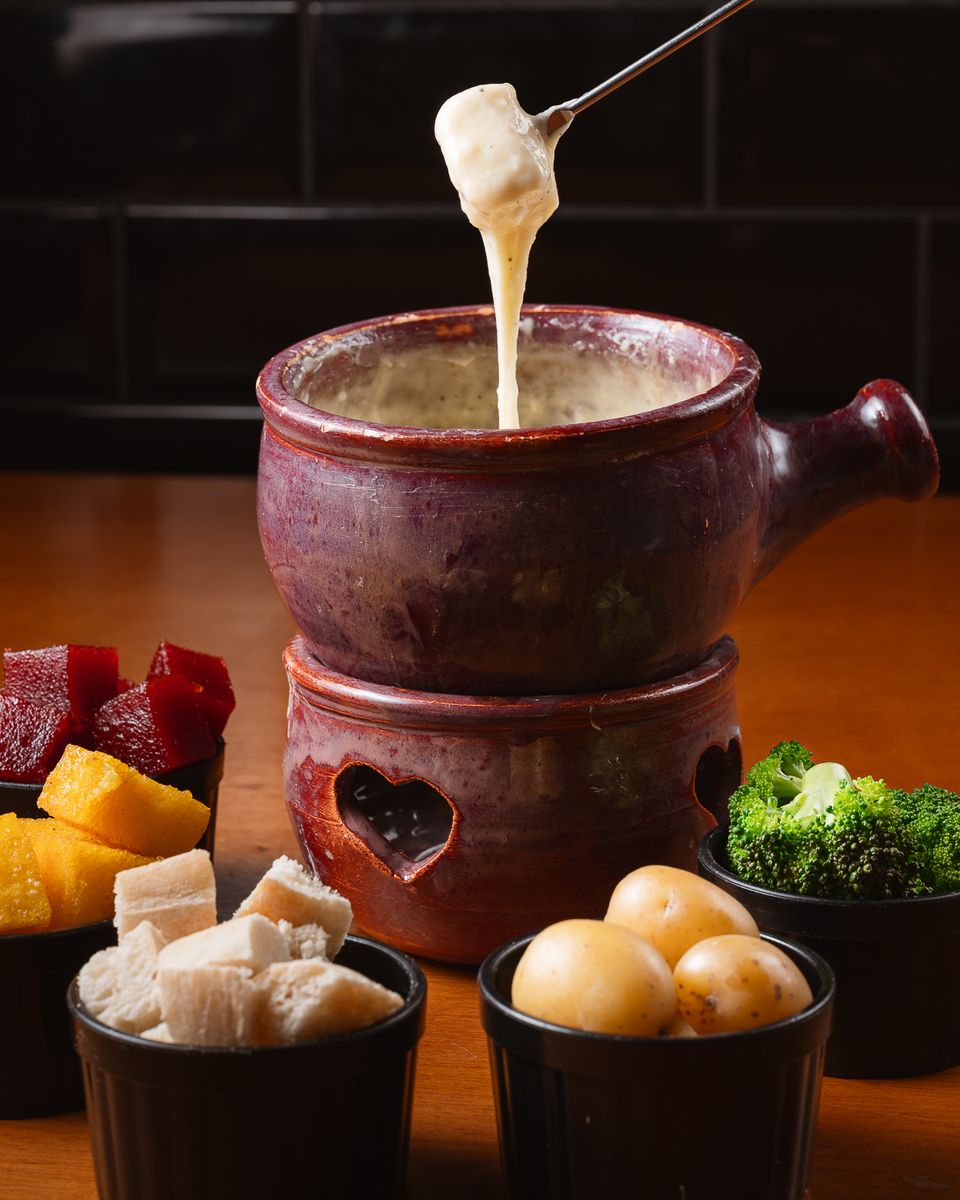 Fondue de queijo na panela de cerâmica, com pão, polenta, goiabada, batata e brócolis